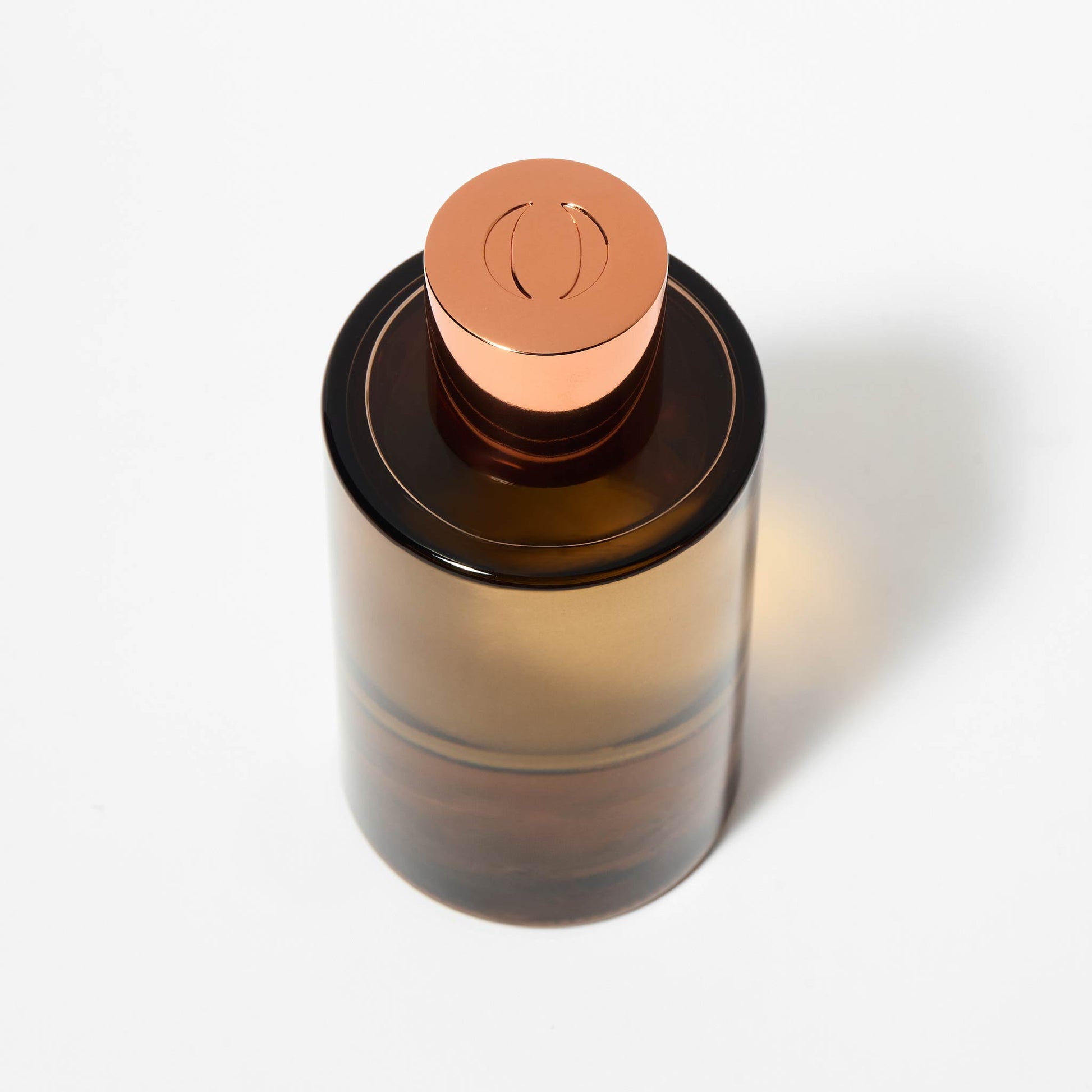 Amber glass bottle with a copper cap on a white background