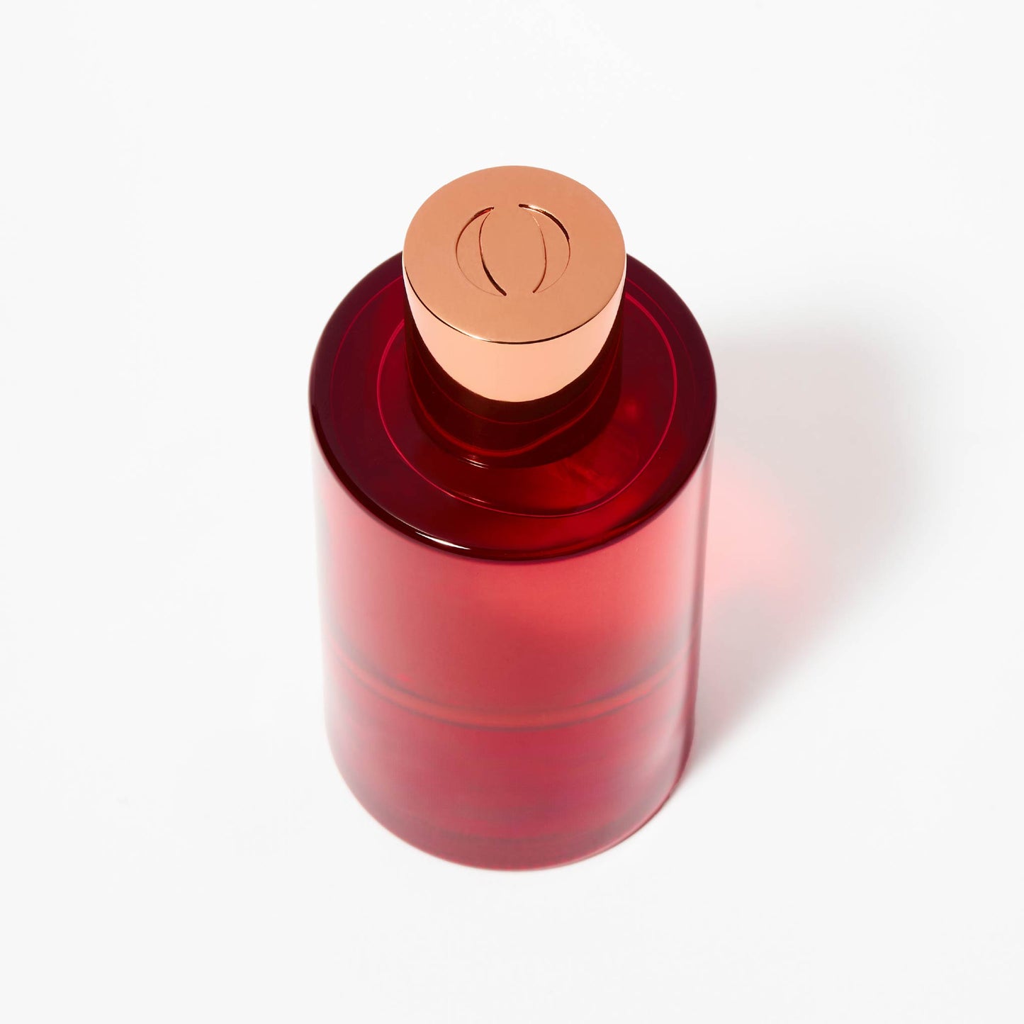 Red bottle with a bronze cap on a white background