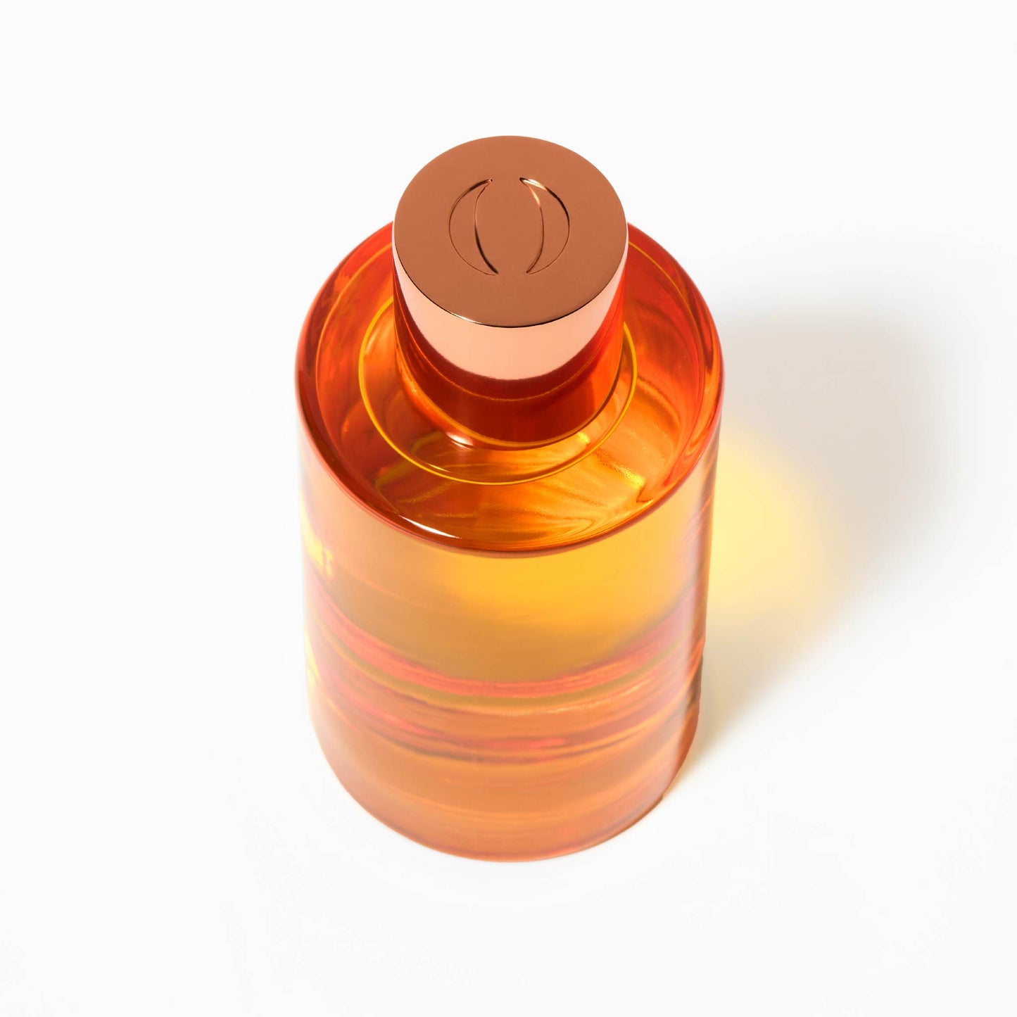 Orange cylindrical bottle with a copper-colored cap on a white background
